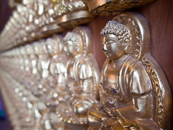 Reihen kleiner Buddhas an der Wand — Stockfoto