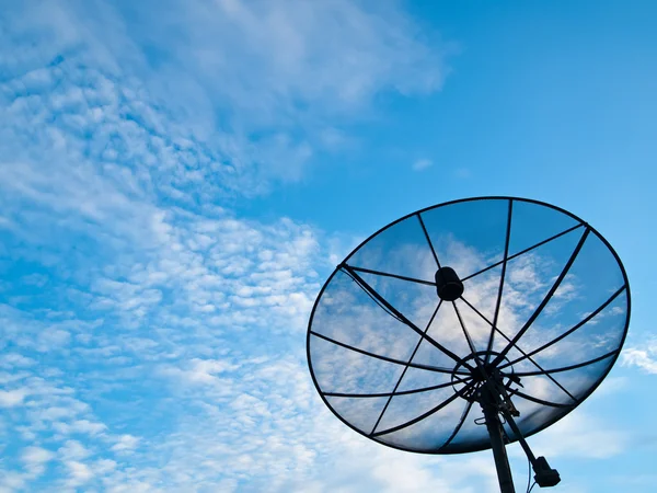 En satellit kommunikation disk på blå himmel bakgrund — Stockfoto