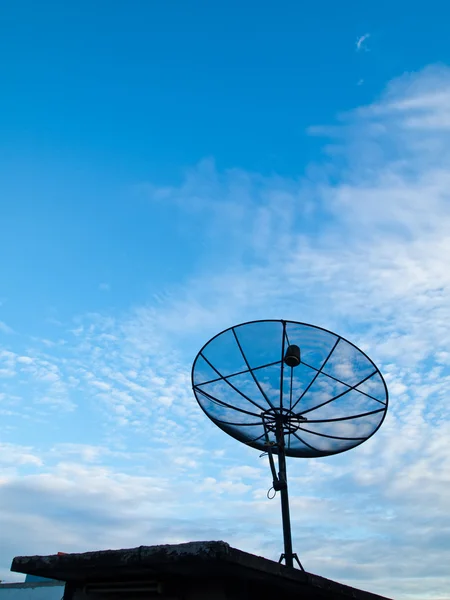 Супутникова тарілка з синім фоном неба на даху — стокове фото