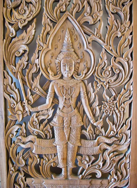 Una estatua de Deva, puerta de madera — Foto de Stock