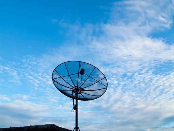 Antena parabólica com fundo céu azul no telhado do meio — Fotografia de Stock