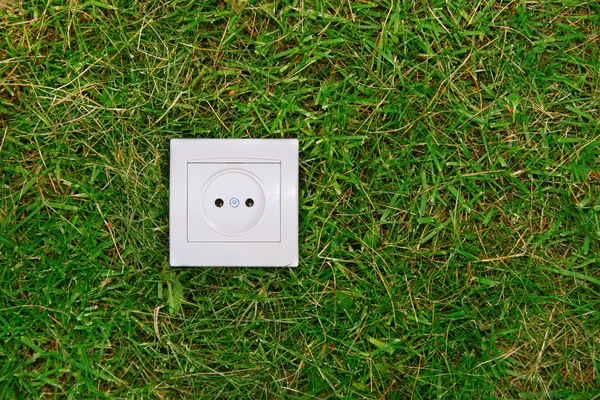 绿色能源概念: 草地上的电源插座 — 图库照片