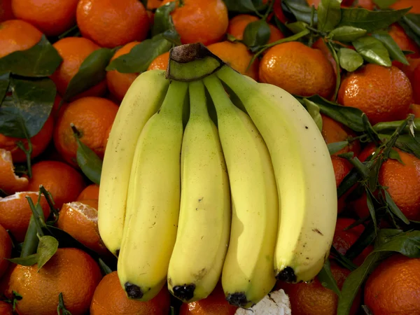 Un paquet de bananes sur un tas de clémentine — Photo