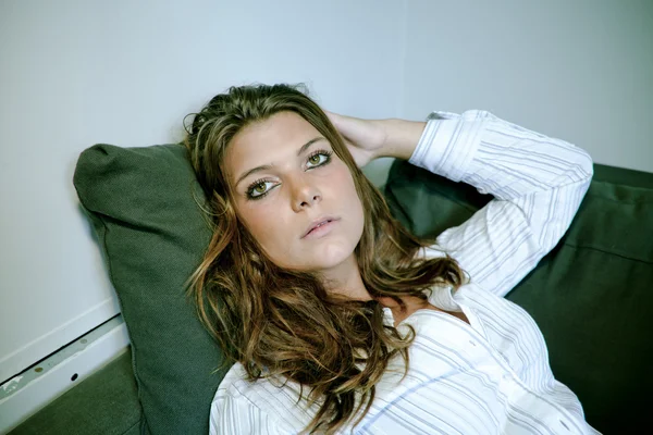 Mladá žena provokativně ležící na pohovce — Stock fotografie