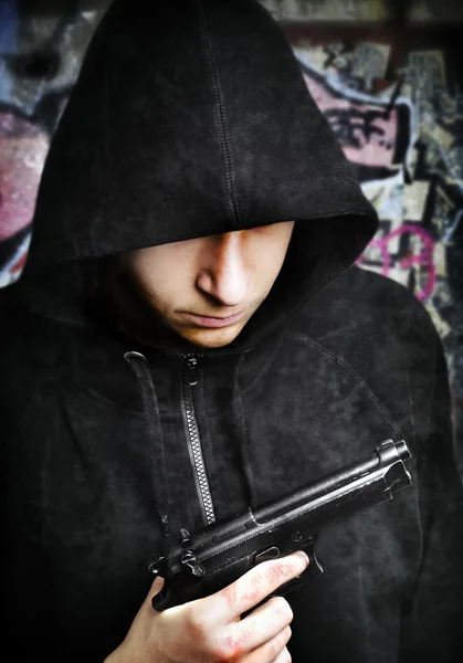One young man with hand gun — Stock Photo, Image