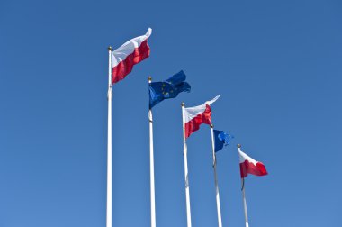 Polish and EU flags on sky background clipart