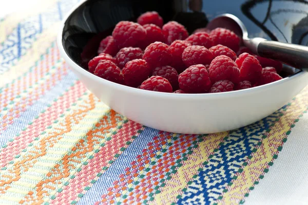 Fresh raspberries on colorful tablecloth — Stock Photo, Image