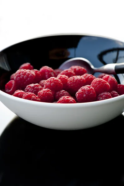 Fresh raspberries in black bowl — Stock Photo, Image