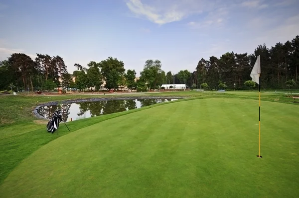 Campo de golf con bolsa blanca y bandera — Foto de Stock