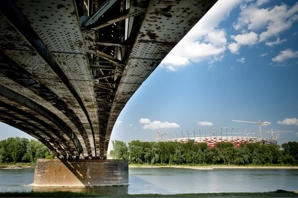 Old bridge in Warsaw with National Stadium construction. — Stock Photo, Image