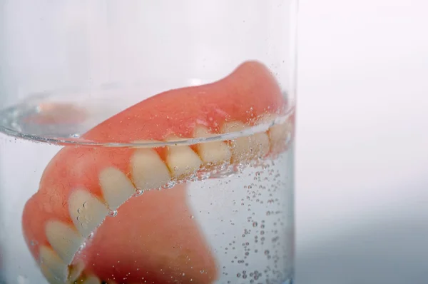 False teeth in glass — Stock Photo, Image