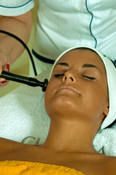Mooie jonge vrouw krijgen gezicht massage. — Stockfoto