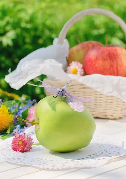 Стрекоза на зеленом яблоке в саду — стоковое фото