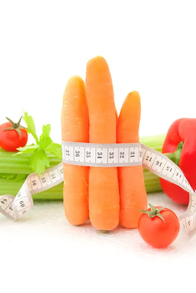 Carrots with tape measure and vegetables — Stock Photo, Image