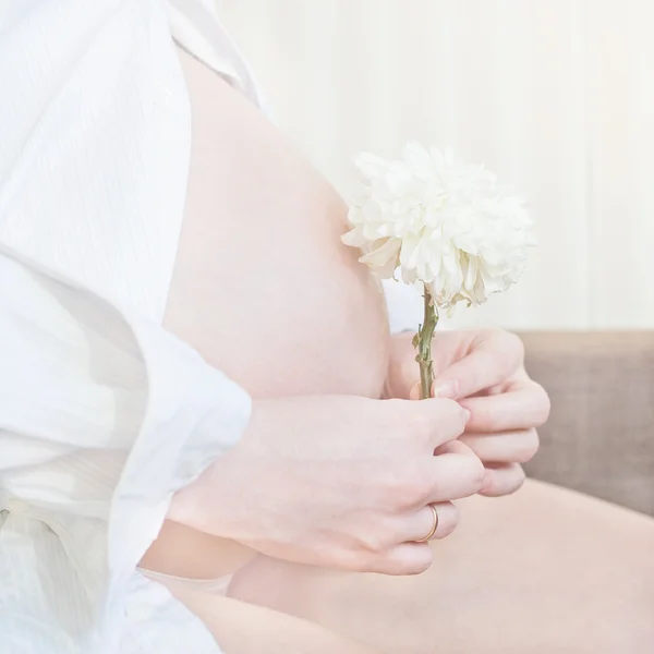 Těhotná žena držící ji — Stock fotografie