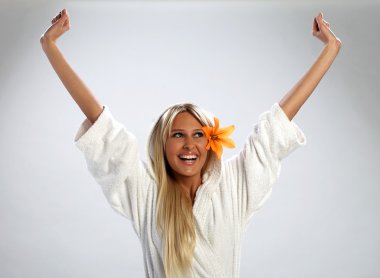 Attractive girl in a white bathrobe feeling happy clipart