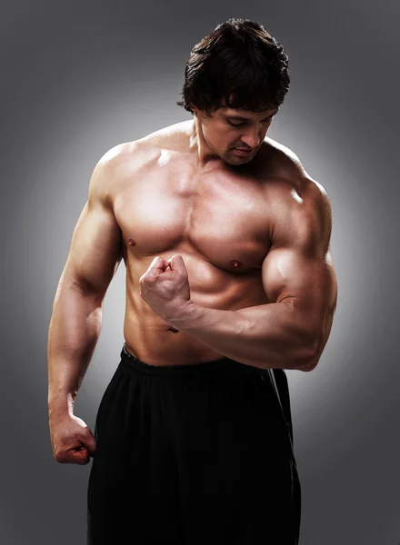 Fisiculturista mostrando seus bíceps — Fotografia de Stock