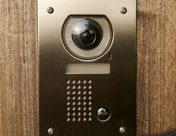 Dörren intercom med kamera på trä Stockfoto
