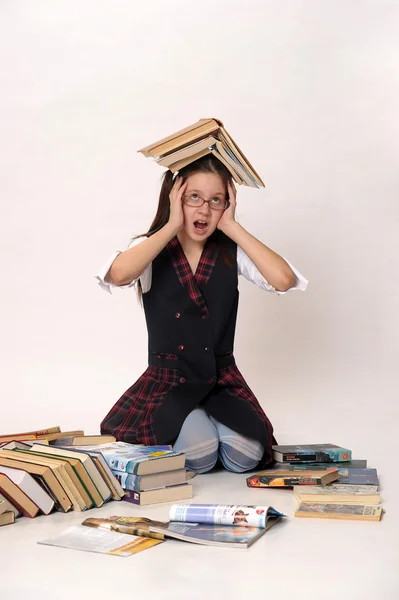 Girl with a big stack of books — Stockfoto