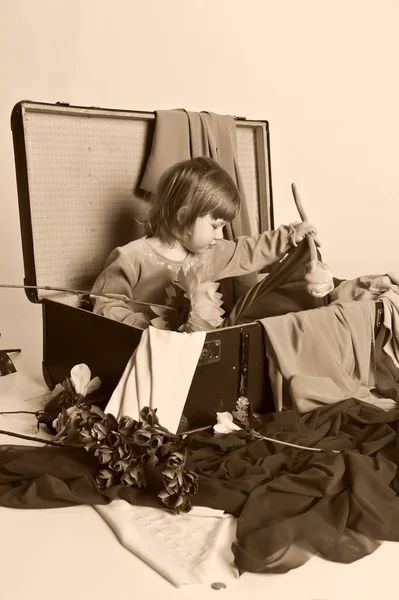 Pieni tyttö ja vanha matkalaukku. — kuvapankkivalokuva