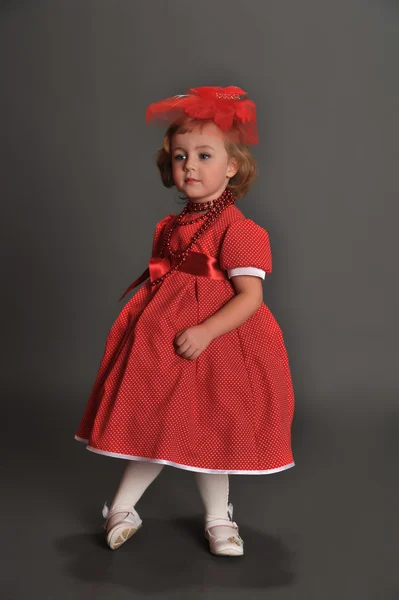 A little girl dressed in a red dress — Stock Photo, Image