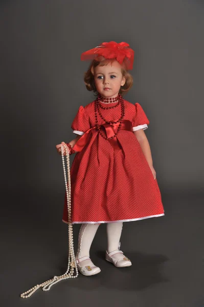 Маленька дівчинка, одягнена в червону сукню — стокове фото