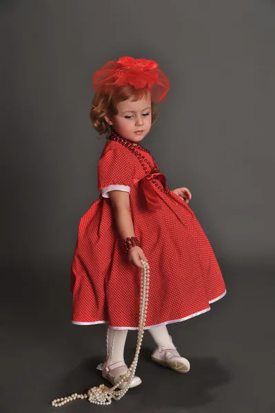 Kırmızı bir elbise giymiş küçük bir kız — Stok fotoğraf