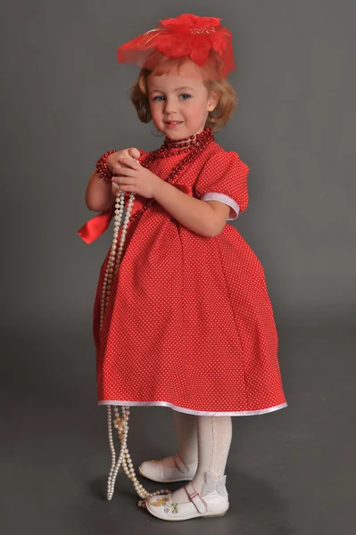 Uma menina vestida com um vestido vermelho — Fotografia de Stock