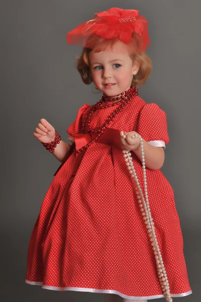 A little girl dressed in a red dress — Stock fotografie
