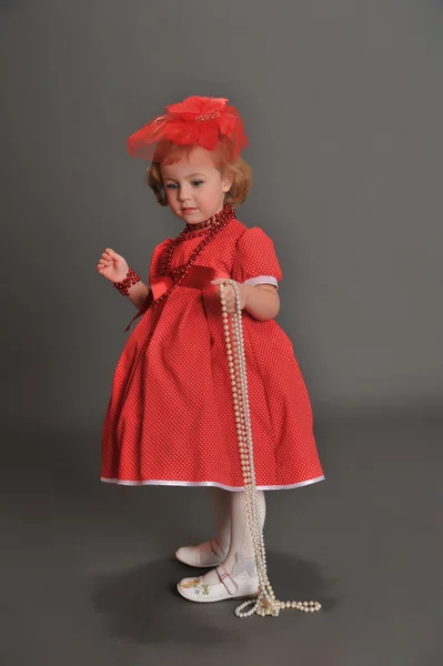 Kırmızı bir elbise giymiş küçük bir kız — Stok fotoğraf