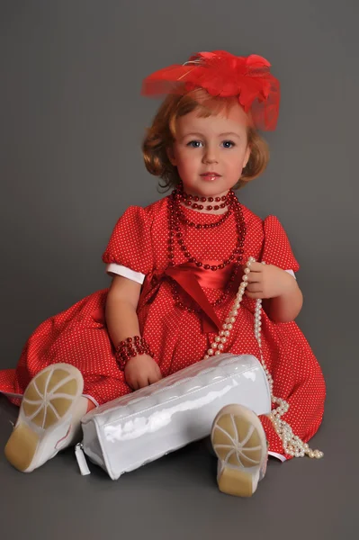 Ein kleines Mädchen in einem roten Kleid — Stockfoto