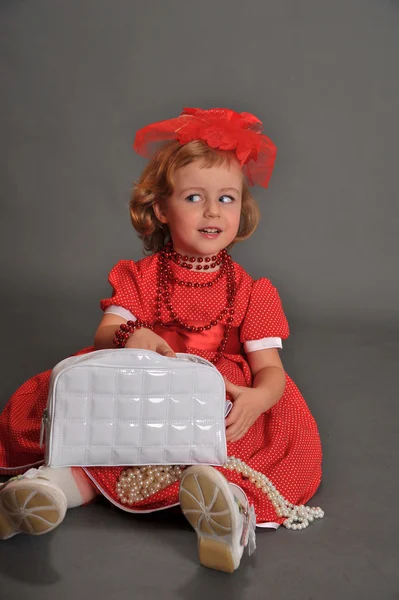 En liten flicka klädd i en röd klänning — Stockfoto