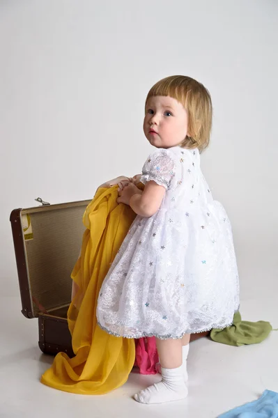 Маленькая девочка и старый чемодан — стоковое фото