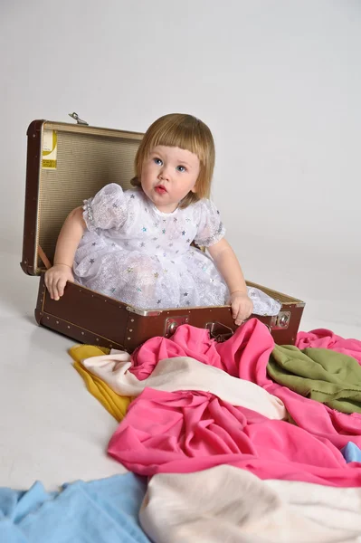 Liten flicka och en gammal resväska — Stockfoto
