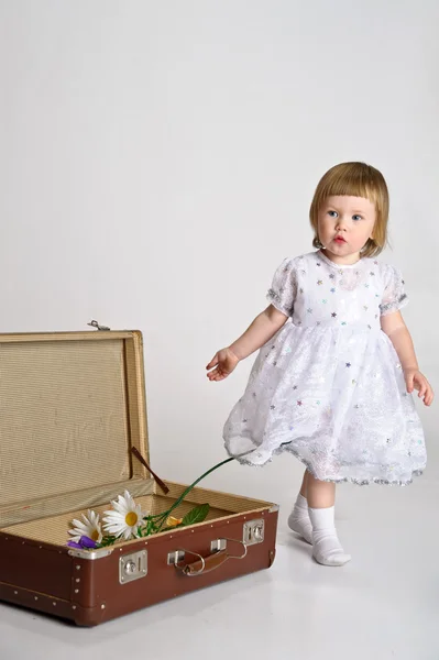 Маленькая девочка и старый чемодан — стоковое фото