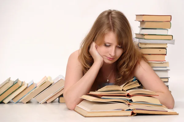 Молода студентка з великою кількістю книг, що навчаються на екзамени — стокове фото