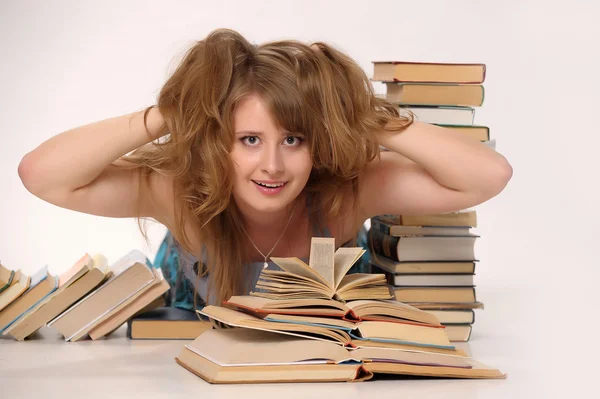 Jovem estudante com muitos livros estudando para exames — Fotografia de Stock