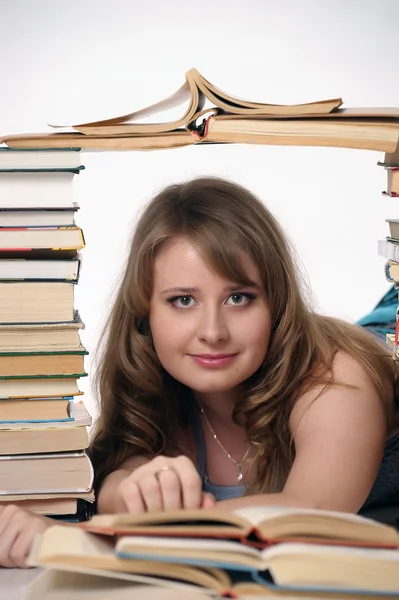 Молодая студентка с большим количеством книг, готовящихся к экзаменам — стоковое фото
