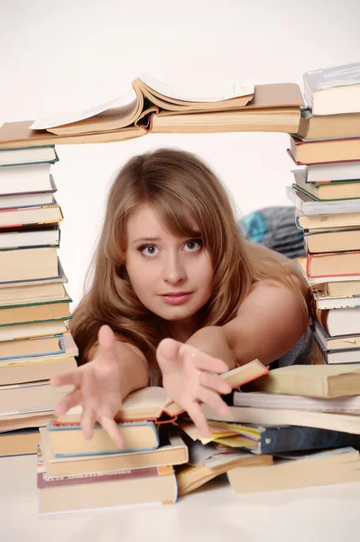 Jovem estudante com muitos livros estudando para exames — Fotografia de Stock