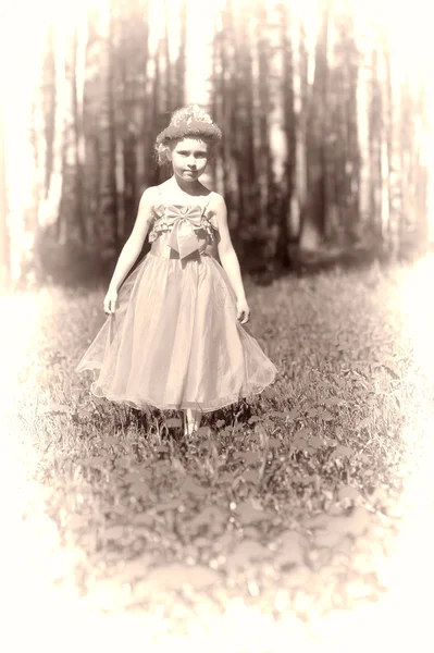 Μικρό κορίτσι στέκεται στο τομέα της πικραλίδες — Φωτογραφία Αρχείου