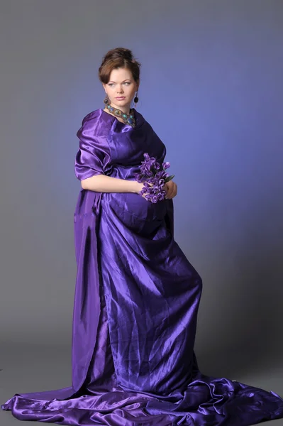 Vackra gravid kvinna i en lila — Stockfoto