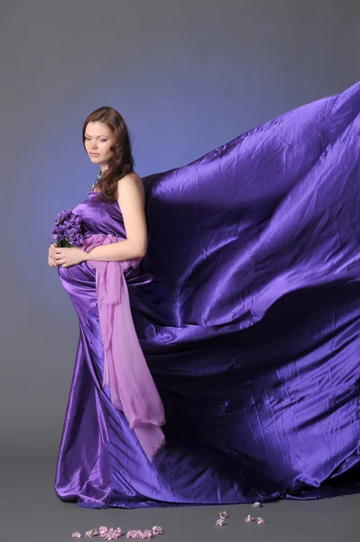 Mulher grávida bonita em um lilás — Fotografia de Stock