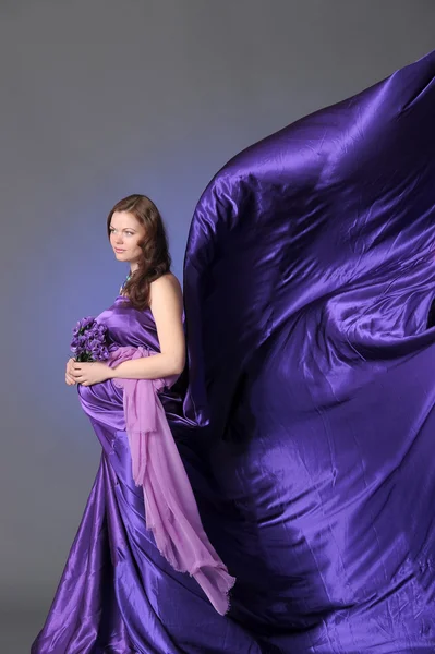 Hermosa mujer embarazada en una lila —  Fotos de Stock