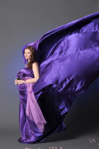 Piękna kobieta w ciąży w liliowy — Zdjęcie stockowe