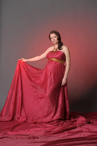 Femme enceinte en robe volante rouge — Photo