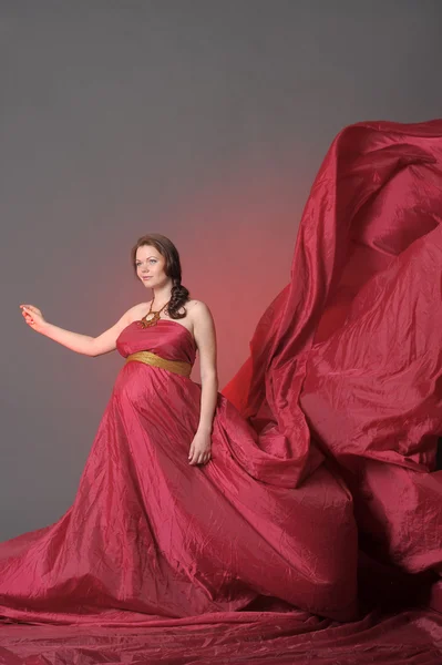 Kırmızı elbise uçan hamile kadın — Stok fotoğraf