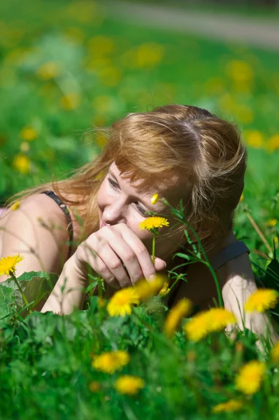 Joven mujer bonita en corona de dientes de león en el prado día solar —  Fotos de Stock