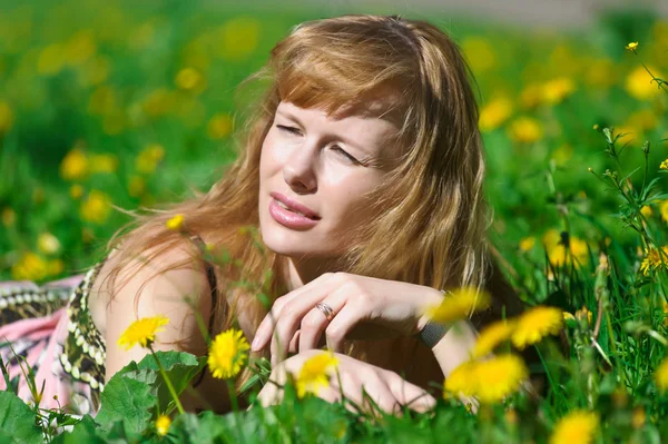 Genç kadın karahindiba çelenk çayır vasatî günün güzel. — Stok fotoğraf
