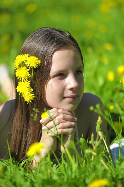 Flickan på ängen med maskros blommor — Stockfoto