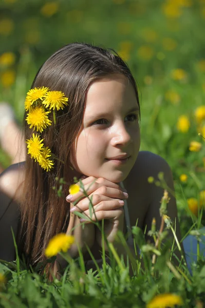 Flickan på ängen med maskros blommor — Stockfoto